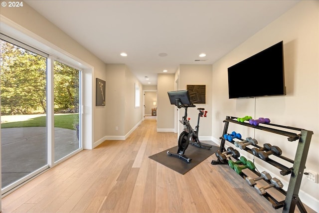 exercise room with light hardwood / wood-style flooring