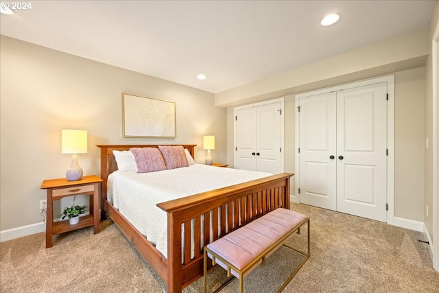 bedroom featuring multiple closets and light colored carpet