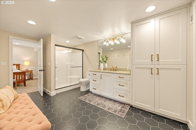 bathroom featuring vanity, toilet, and a shower with door