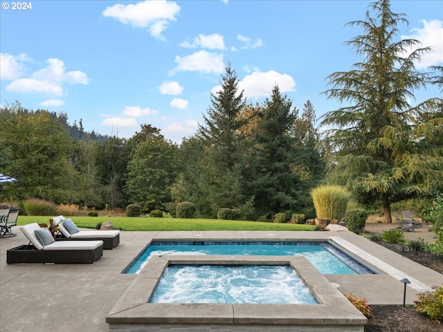 view of pool with an in ground hot tub, a patio area, and a lawn