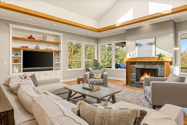 living room featuring ornamental molding, a high end fireplace, light hardwood / wood-style floors, and lofted ceiling