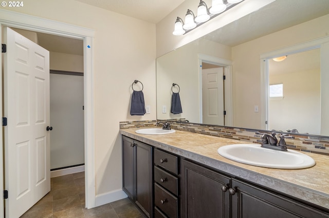 bathroom with tile patterned floors, decorative backsplash, and dual vanity