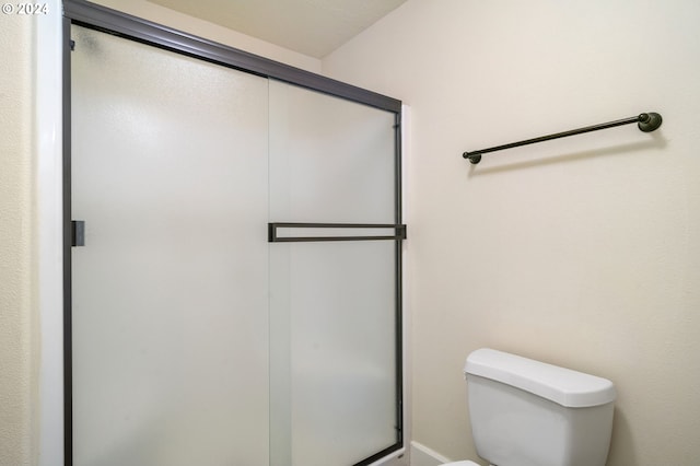 bathroom with an enclosed shower and toilet