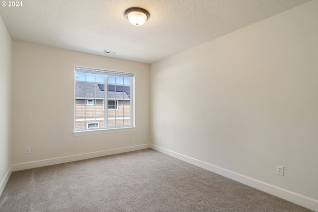 unfurnished room featuring a textured ceiling and carpet floors