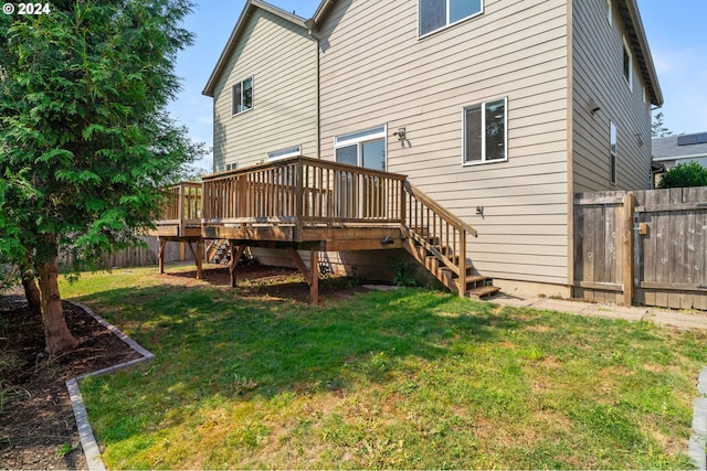 back of house with a deck and a yard