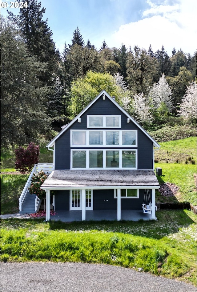 view of front facade with a front lawn, a patio, and central air condition unit