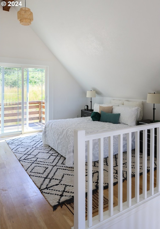 bedroom featuring lofted ceiling, hardwood / wood-style floors, and access to exterior