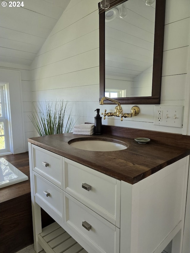 bathroom with lofted ceiling, vanity, and wood-type flooring