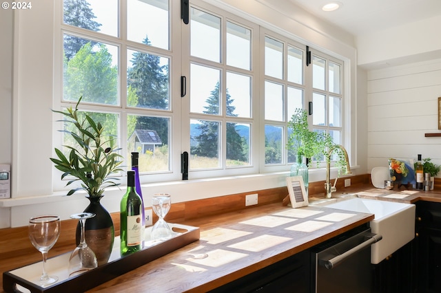 interior space with dishwasher, indoor wet bar, and wood walls