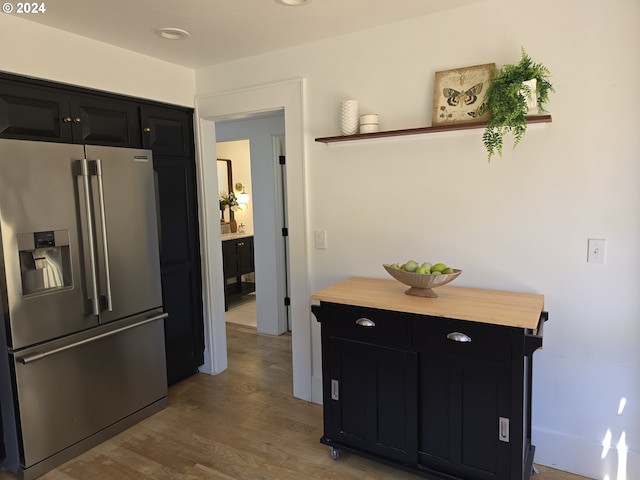 kitchen featuring butcher block counters, stainless steel fridge with ice dispenser, and light hardwood / wood-style flooring