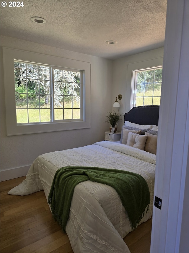 bedroom with hardwood / wood-style flooring and a textured ceiling