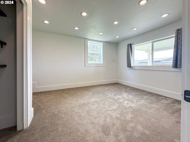 carpeted spare room featuring a textured ceiling