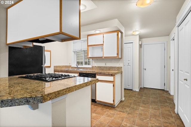 kitchen with sink, black fridge, white cabinetry, stainless steel dishwasher, and gas stovetop