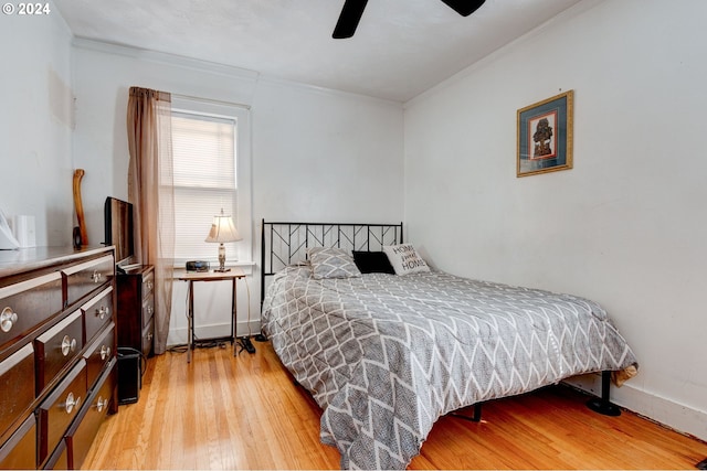 bedroom featuring light hardwood / wood-style floors, ornamental molding, and ceiling fan