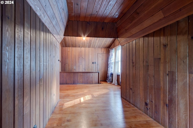 bonus room featuring wooden walls, vaulted ceiling, wood ceiling, and light hardwood / wood-style floors