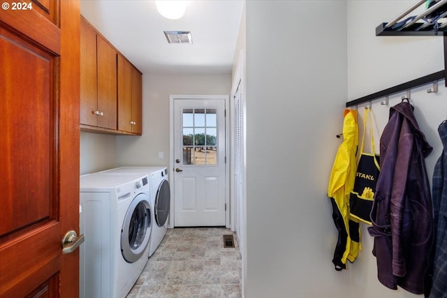 laundry area featuring washer and dryer and cabinets