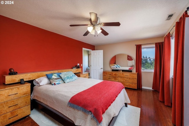 bedroom featuring ceiling fan, dark wood-type flooring, and a textured ceiling