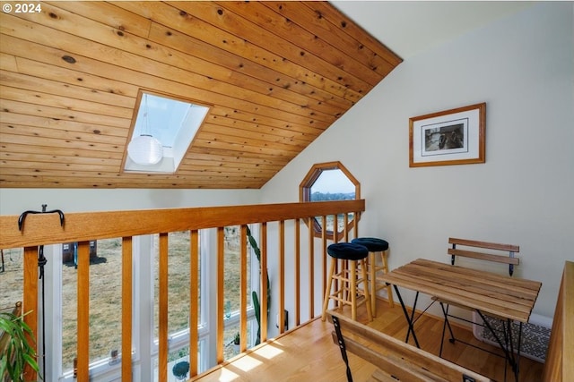 hall featuring wooden ceiling, lofted ceiling with skylight, and light wood-type flooring