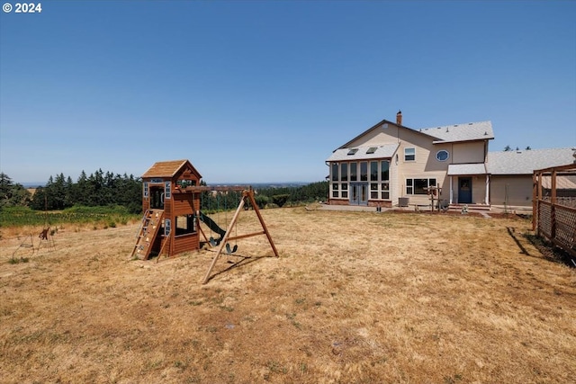 view of yard with a playground and a sunroom