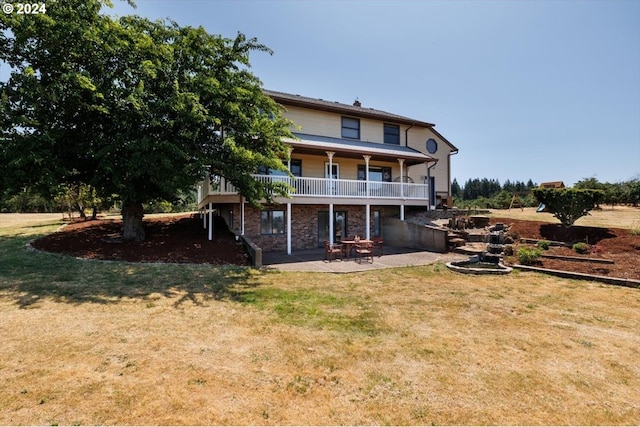 rear view of house featuring a lawn and a patio area