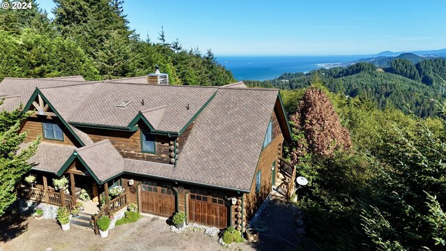 birds eye view of property featuring a forest view and a mountain view