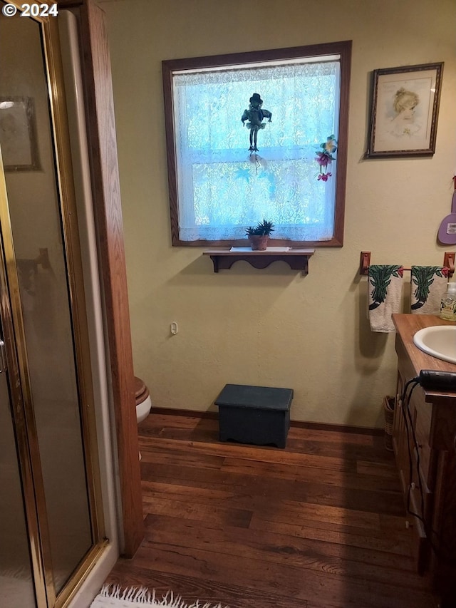 bathroom featuring hardwood / wood-style flooring, vanity, toilet, and an enclosed shower