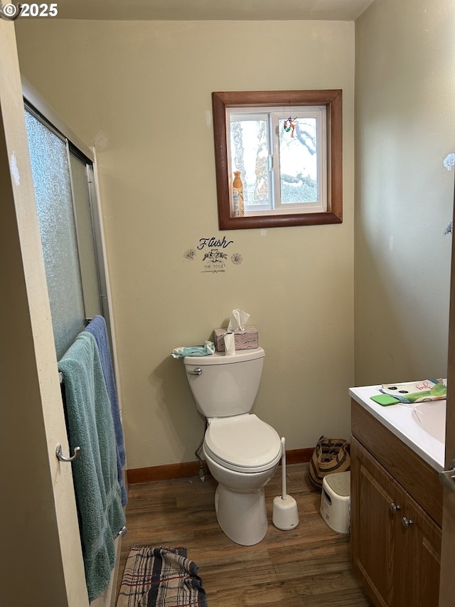 bathroom featuring wood-type flooring, toilet, and vanity