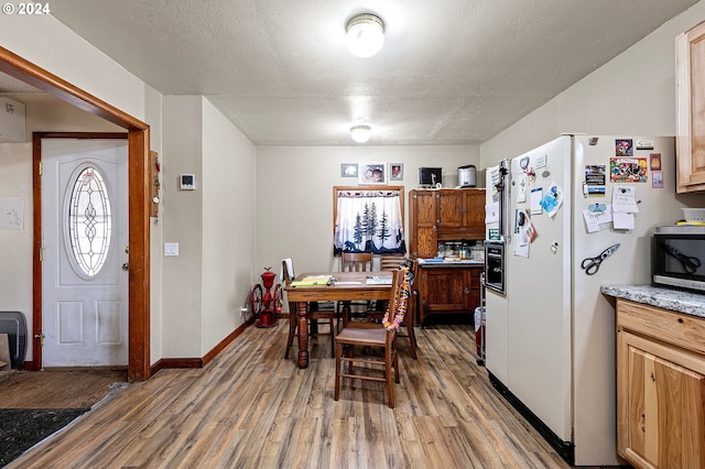 dining space featuring hardwood / wood-style floors and a textured ceiling