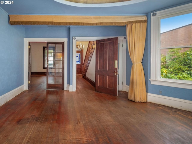 spare room with plenty of natural light and dark wood-type flooring