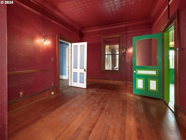 unfurnished room featuring crown molding and hardwood / wood-style floors