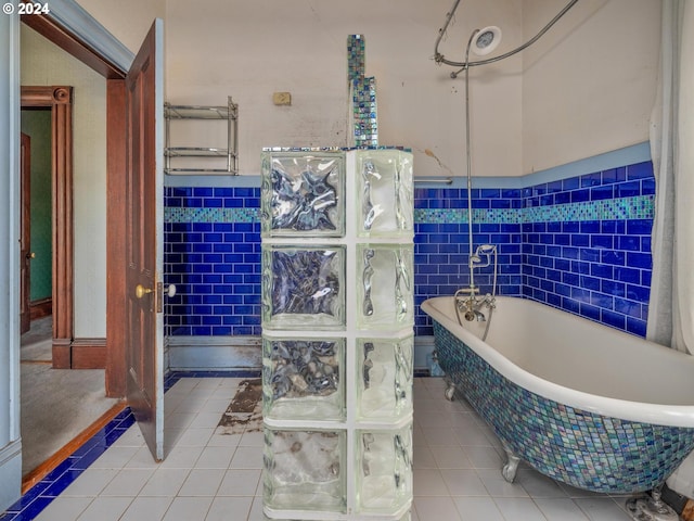 bathroom featuring a bathtub, tile patterned floors, and tile walls