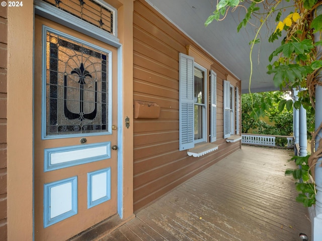 view of exterior entry featuring covered porch