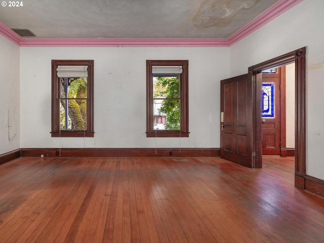 spare room with hardwood / wood-style flooring, crown molding, and a wealth of natural light