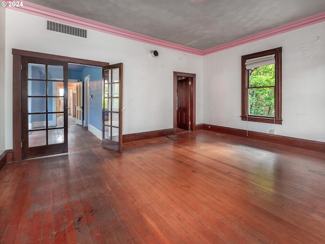 spare room featuring dark wood-type flooring, french doors, and crown molding