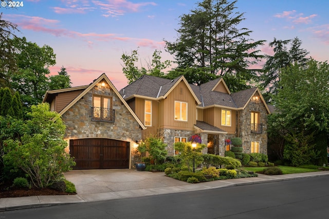 view of front of home with a balcony, board and batten siding, a garage, and concrete driveway