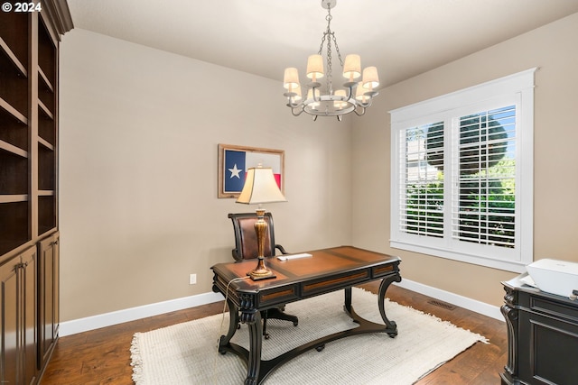 office area with dark wood-type flooring and an inviting chandelier