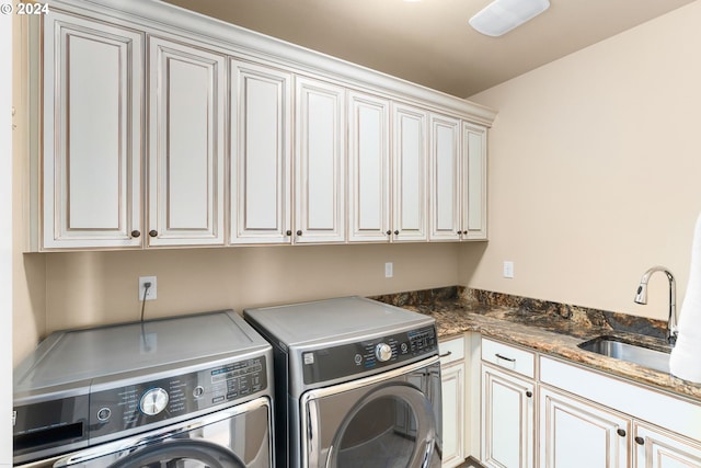 laundry room with cabinets, washer and clothes dryer, and sink