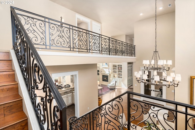 stairway with a high ceiling and a notable chandelier