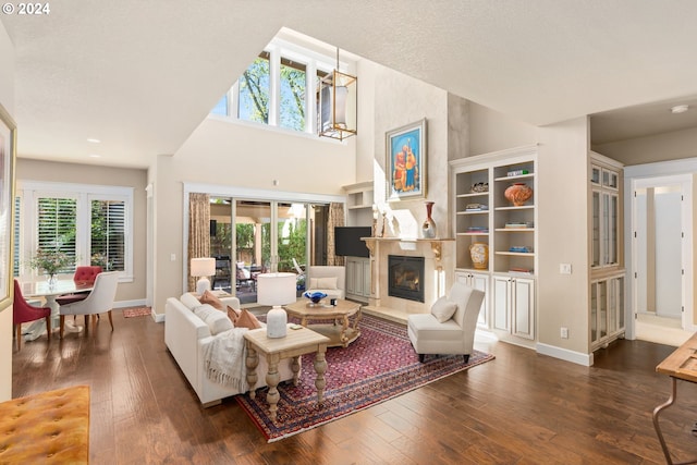 living room with a large fireplace, a chandelier, and dark hardwood / wood-style floors