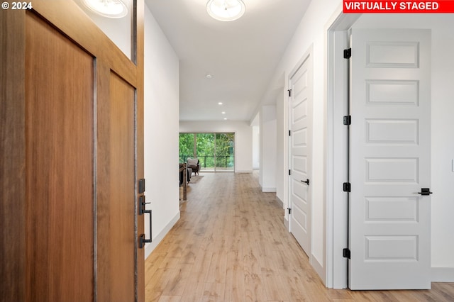 hallway with light hardwood / wood-style floors