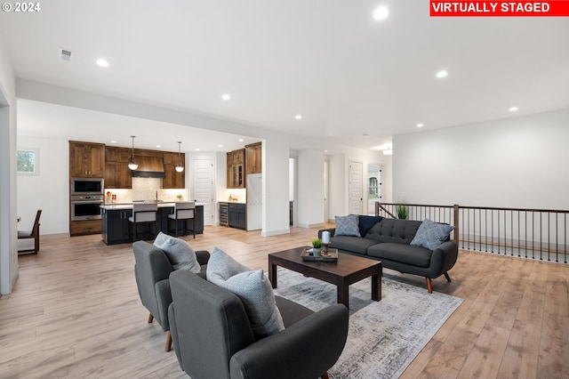 living room featuring sink and light hardwood / wood-style flooring