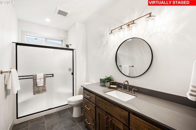 bathroom with vanity, toilet, tile patterned floors, and walk in shower