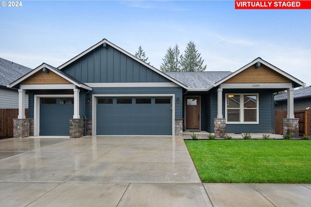 craftsman-style home featuring a garage and a front yard