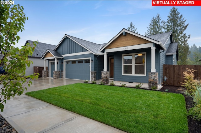 craftsman-style home featuring a garage and a front yard