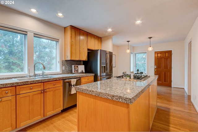 kitchen with light hardwood / wood-style floors, sink, a center island with sink, and stainless steel appliances