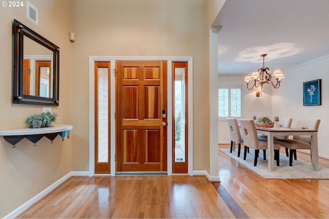 entrance foyer with light hardwood / wood-style floors, an inviting chandelier, and a textured ceiling