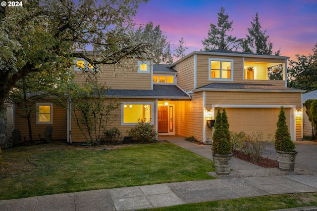 front facade featuring a lawn and a garage