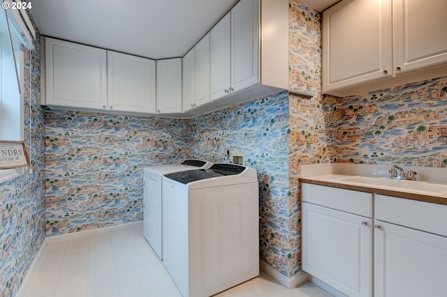 laundry area with sink, washer and clothes dryer, and cabinets