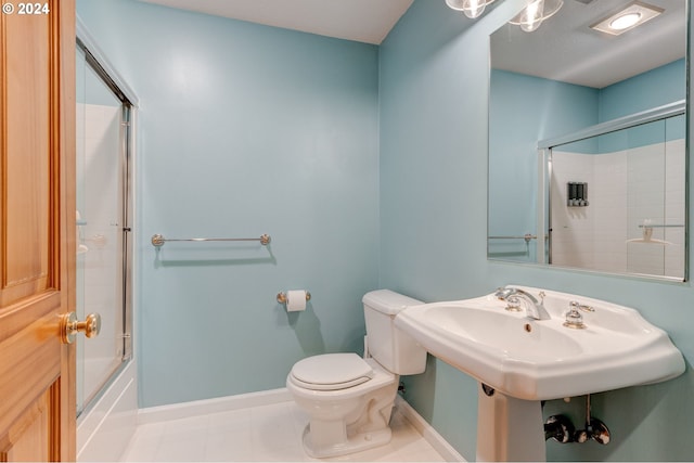 bathroom featuring tile patterned floors, enclosed tub / shower combo, and toilet