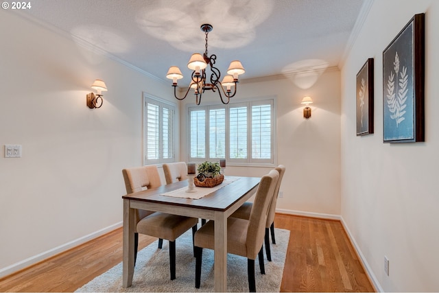 dining area with a chandelier, crown molding, a textured ceiling, and light wood-type flooring